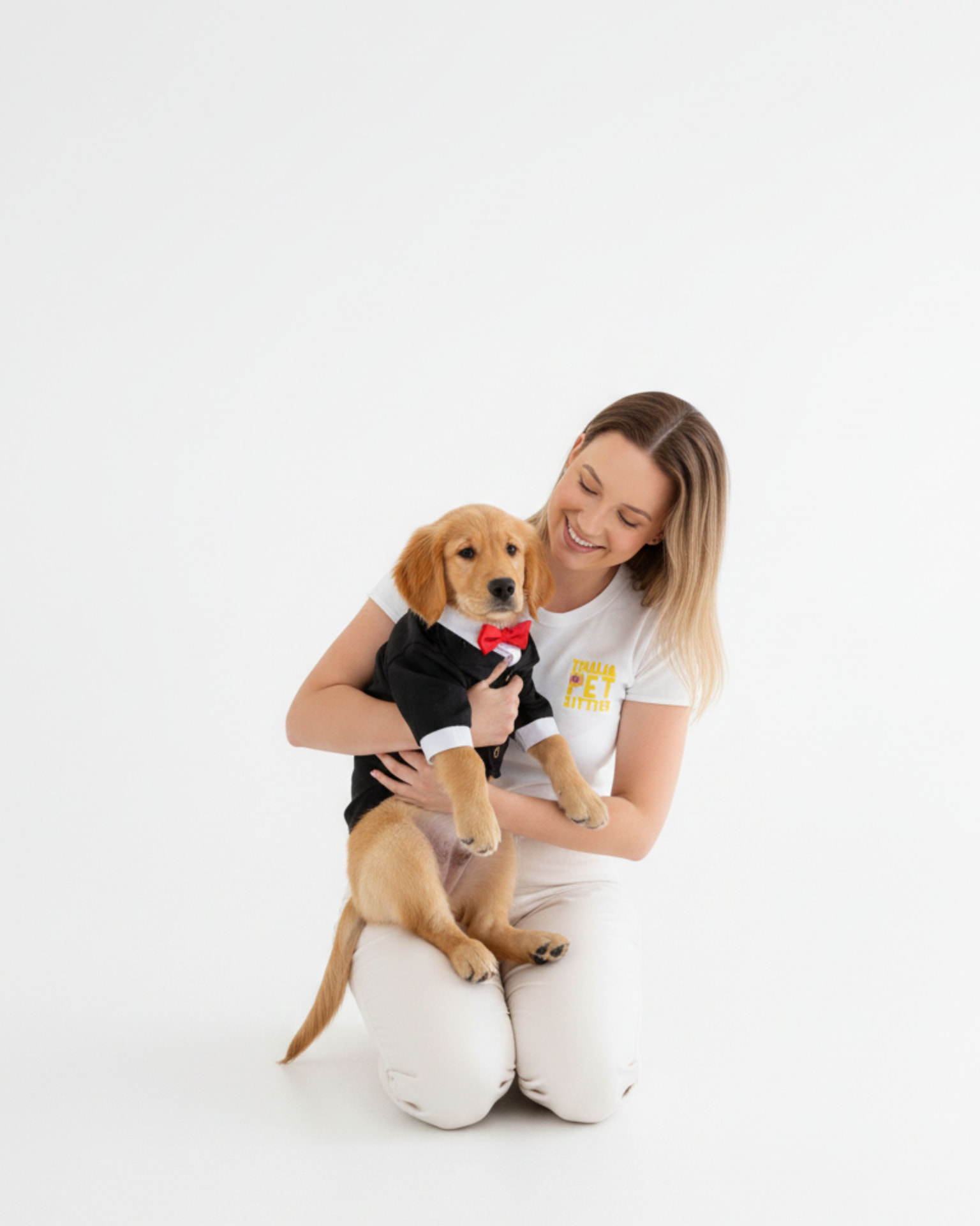 Thalia segurando um cachorro vestido para casamento