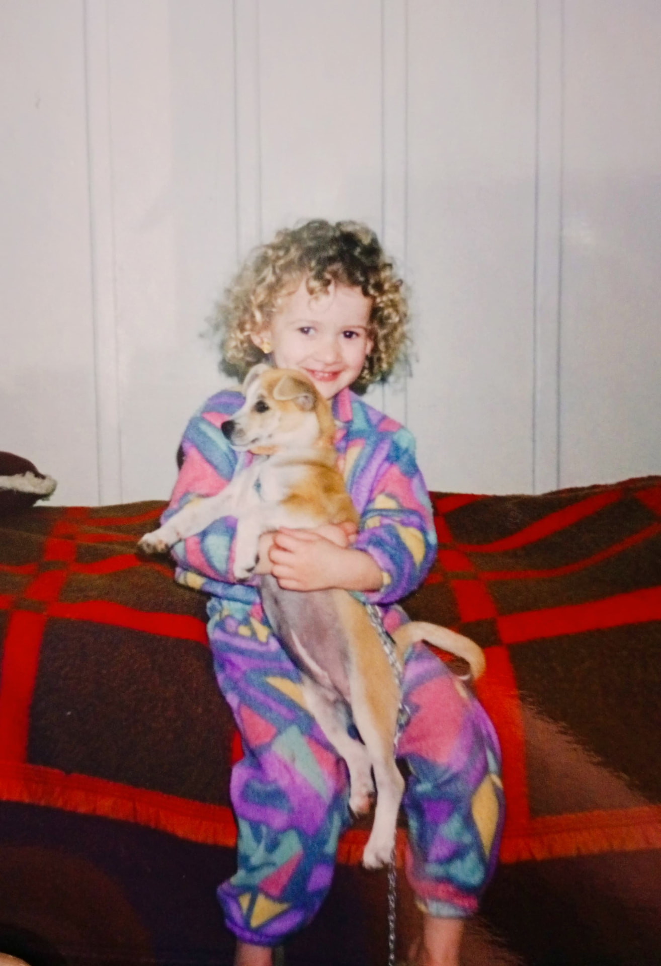 Thalia ainda criança segurando seu cachorro